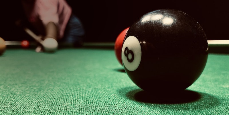 An eight ball on a pool table.