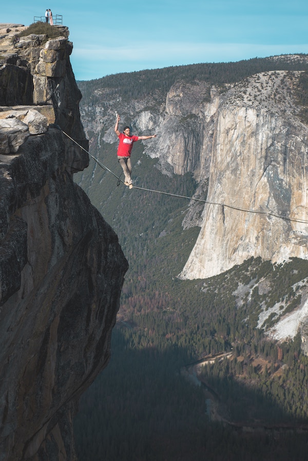 A man walking
    across a canyon on a tighrope.